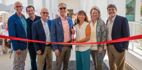 Strom Tacker stands with several other in back of an orange ribbon at the Nucleus ribbon-cutting ceremony