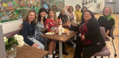Andrea Robinwitz sits at a table with several women at CASA Pitzer