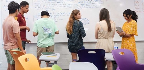Students writing on the board in classroom