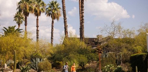 two student walk in front of the grove house  on a sunny day