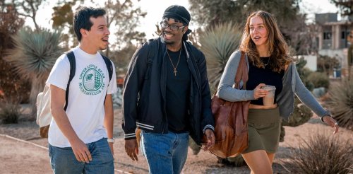 Three students walk to class through the Holden Garden
