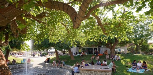 families sit on the mounds near the fountain
