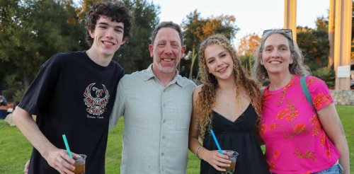 two students pose with their parents on the mounds