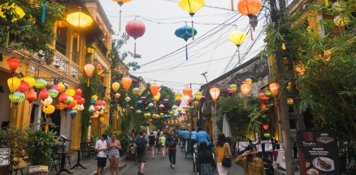 People walking through streets with lanterns