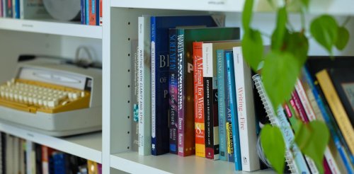 bookcase featuring a typewriter and plants
