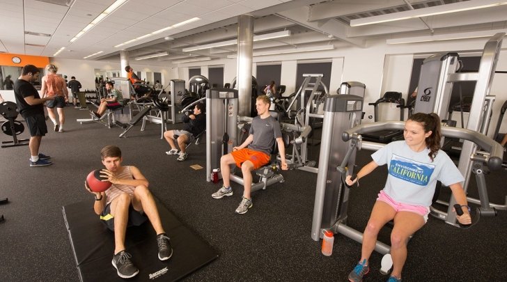 Students use exercise machines in the Gold Student Center gym