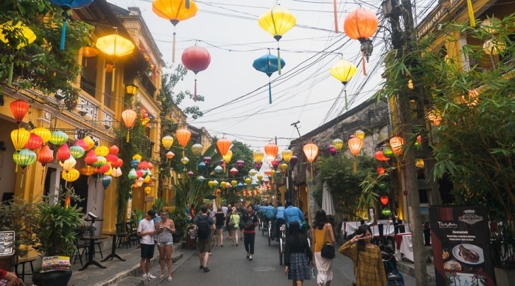 a colorful street decorated with paper lanterns in Hoi An, Vietnam