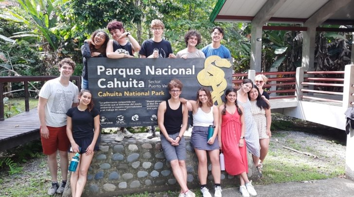 Students pose in front of national park sign in Costa Rica