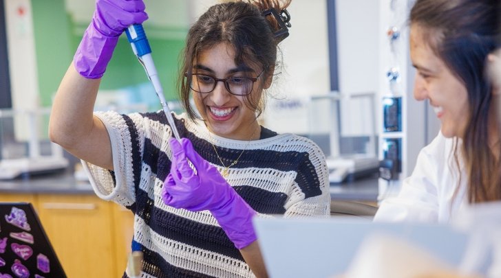 A student pipettes a liquid in a chemistry lab