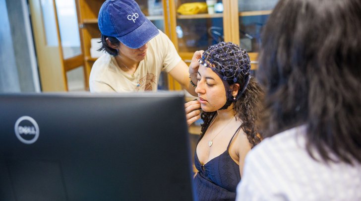 A student has a brainwave measuring device affixed to their head