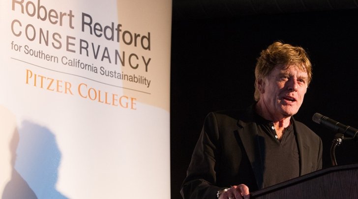 robert redford speaks at a podium