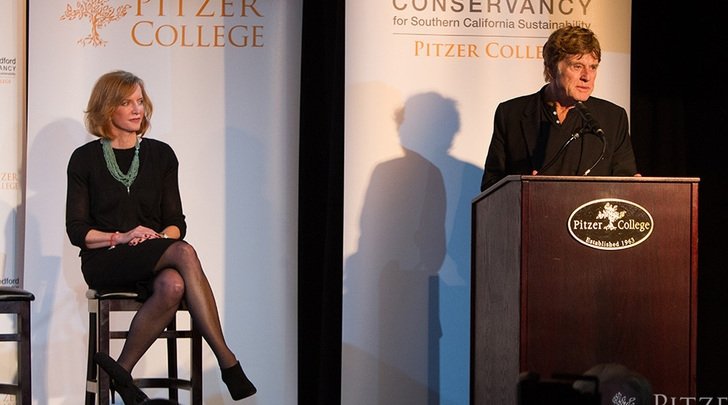 Robert Redford makes a speech while president laura trombley look on