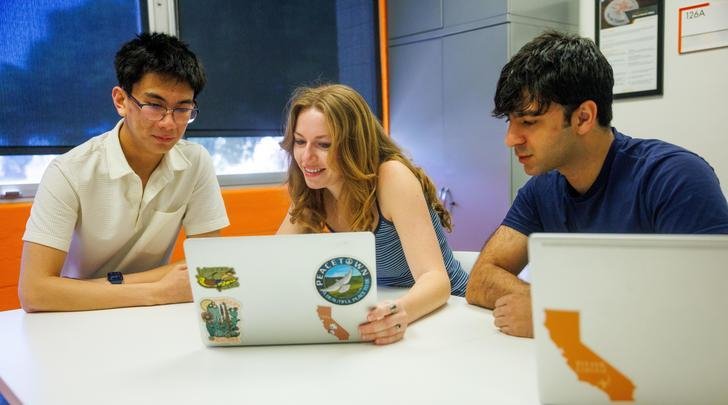 two students work with a career services counselor 