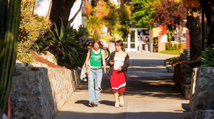 Two students walk next to Commencement Plaza