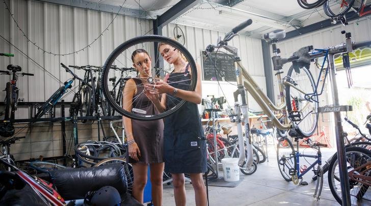 two students work in the green bike garage
