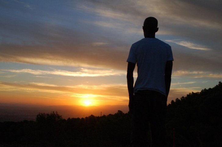silhouette of a man looking into the sunset