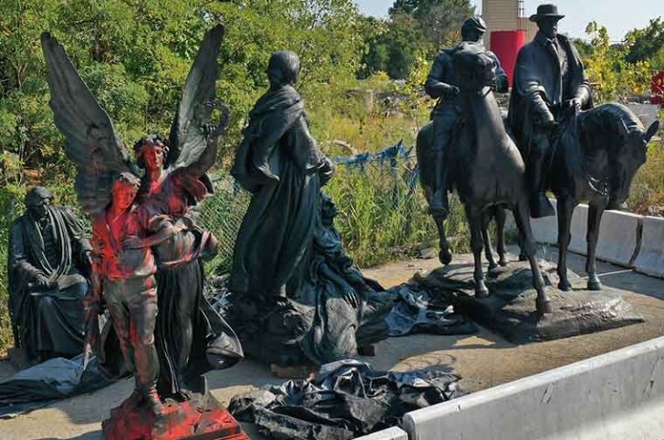 four metal statutes covered in red paint