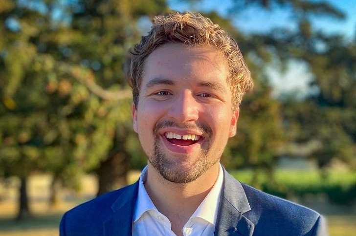Aidan Henrikson has short blond hair and a light beard and wears a blue blazer over a white shirt.