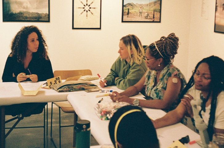 Students and faculty write on white paper covering the tables in Pitzer’s Salathe Gallery.
