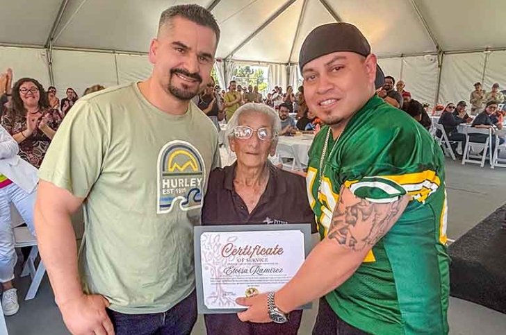 two pitzer staff members pose with Eloisa Ramirez and her certificate at the staff recognition lunch