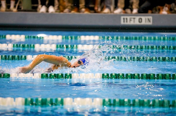 A student on the Pomona-Pitzer women's swimming and diving team swims freestyle during a meet
