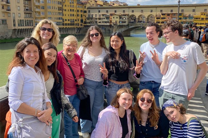 a group of students pose near a river
