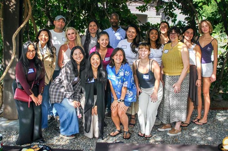 a group of alumni pose in the outdoor classroom