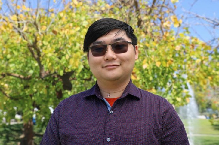 Robinson Lee stands in front of the fountain on the mounds