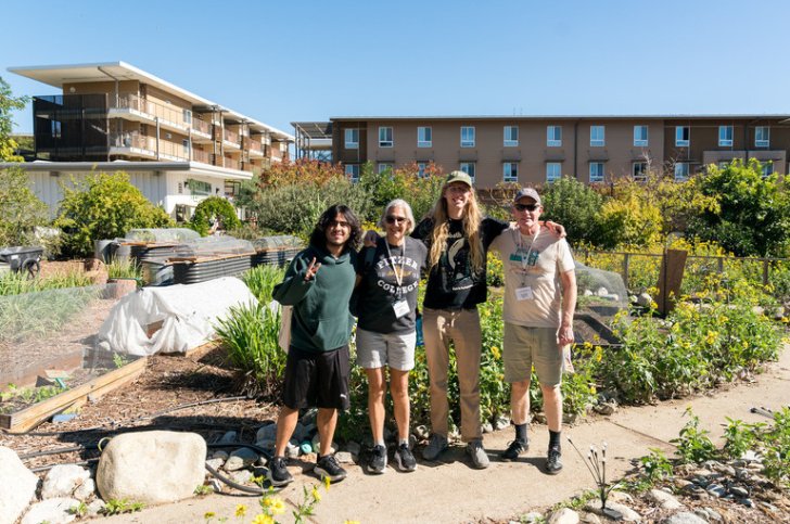 a family stands together in the student garden