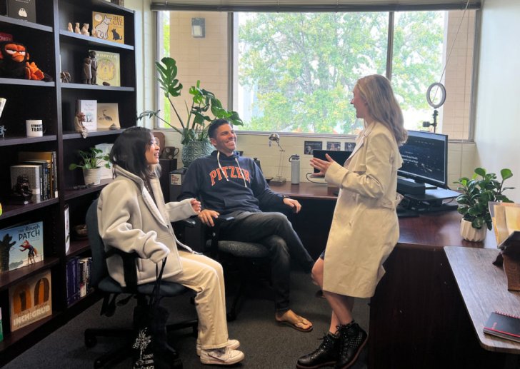 professor marcus rodriguez talks to students in his office. 
