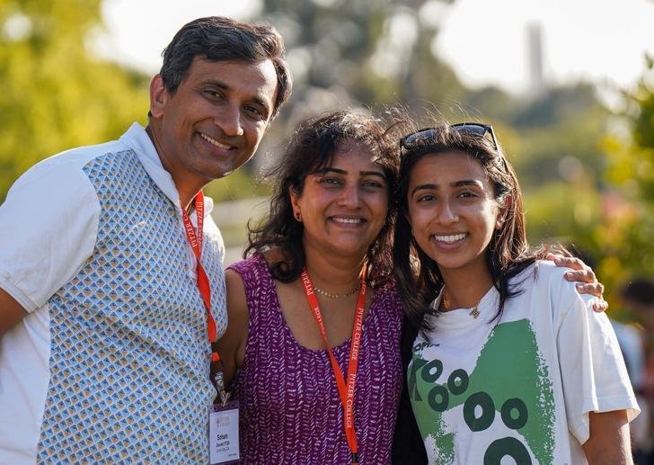 a student and their parents pose for the camera