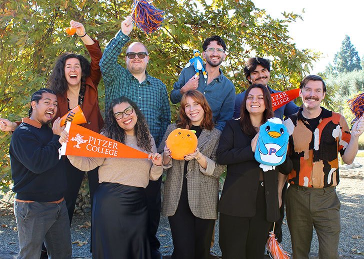 a group of admissions counselors hold up Pitzer gear and merch