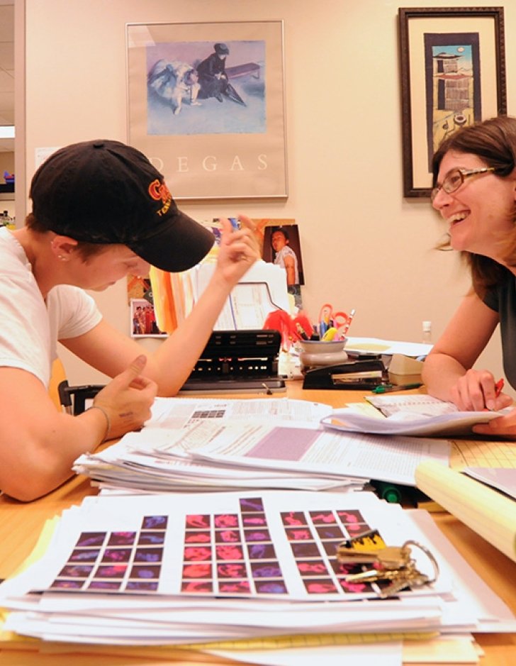 A biology professor advises a student in their office