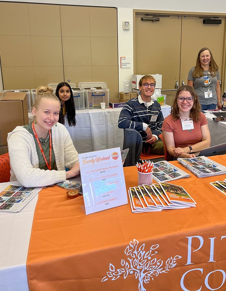 a group of ambassadors help check people in at family weekend