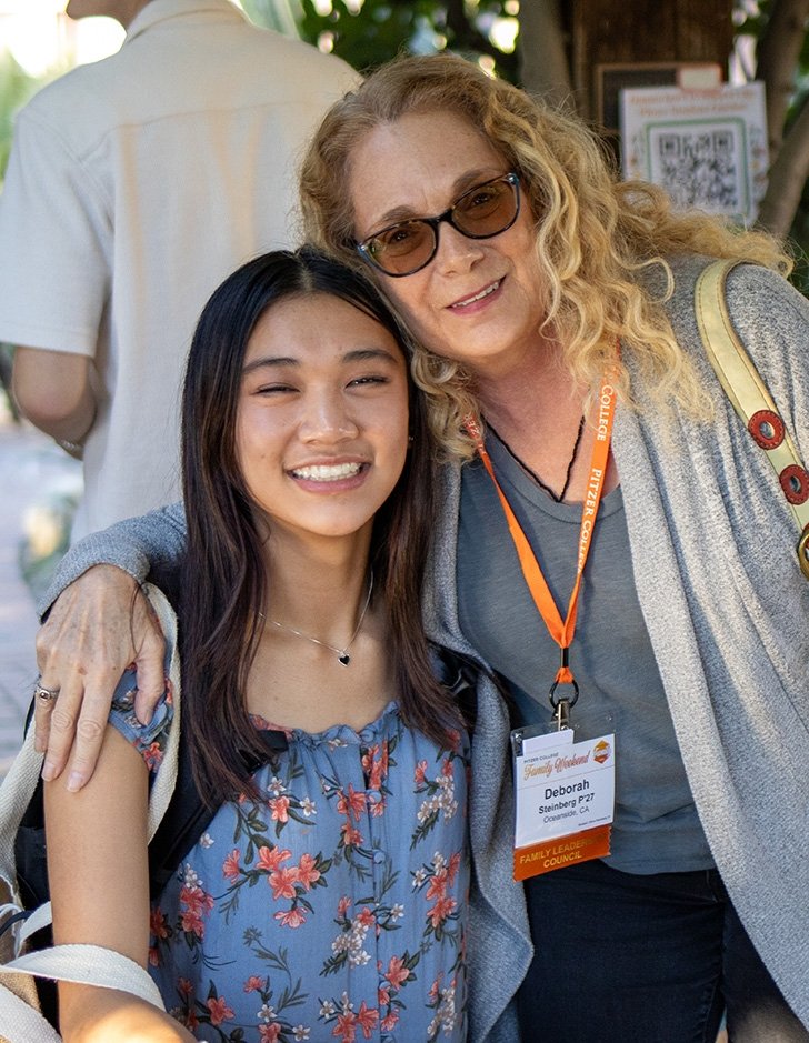 a student and their parent pose for the camera outside of the grove house