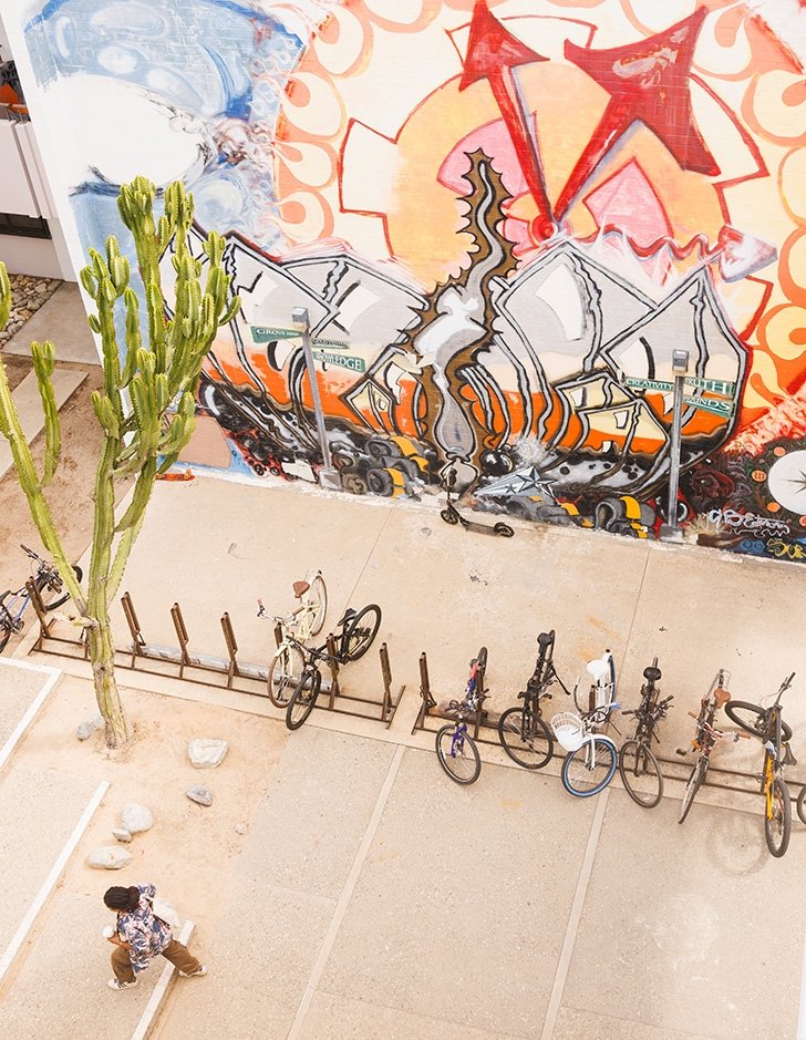 a student walks past parked bikes and a mural in mead courtyard