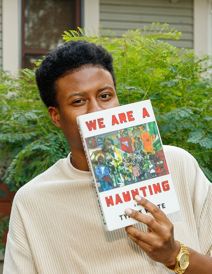 tyriek white holds up his novel "we are a haunting"