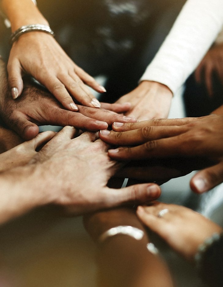 photo of multiple hands used for multi-racial unity story on participant