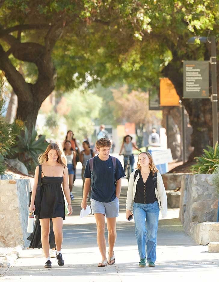 several students walk down Pitzer walk towards the pitzer gate