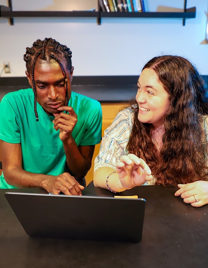 Richard Ampah and Sarah Marzen look at a laptop