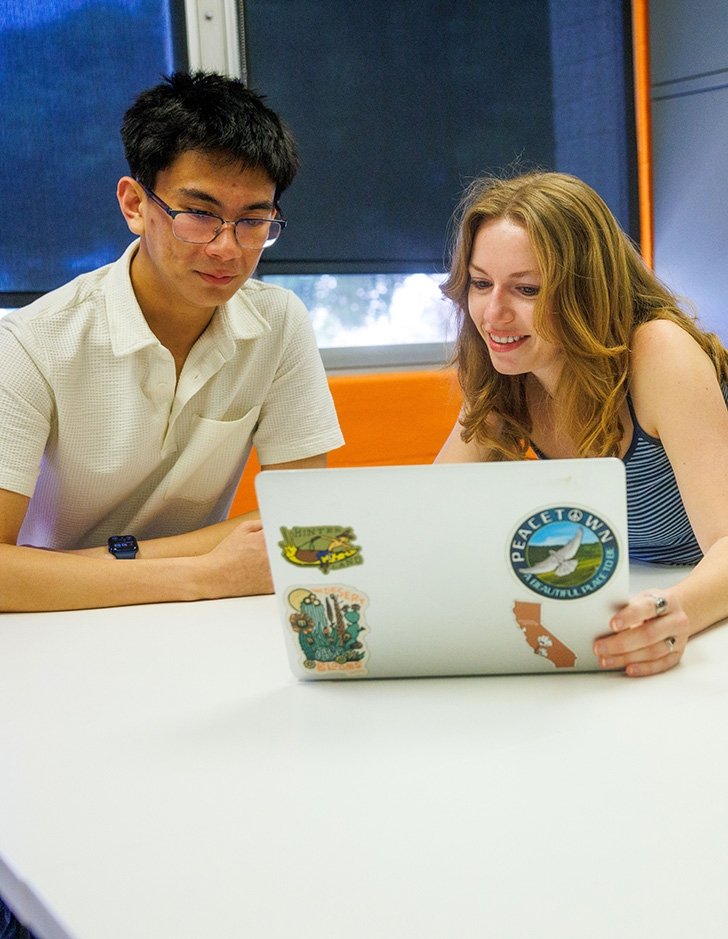 Two students work on a laptop in the Career Services office