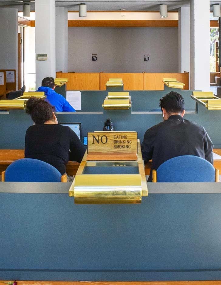 three students do work in Marquis Library