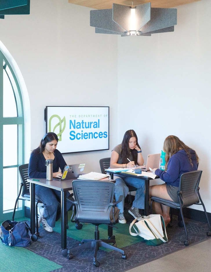 three students sit at a study station in the Nucleus West
