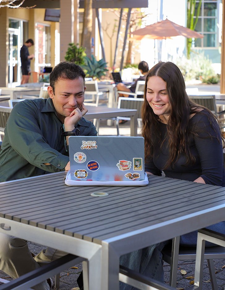 Professor Fanthome and Siena Giacoma sit at a table together in Scott Courtyard