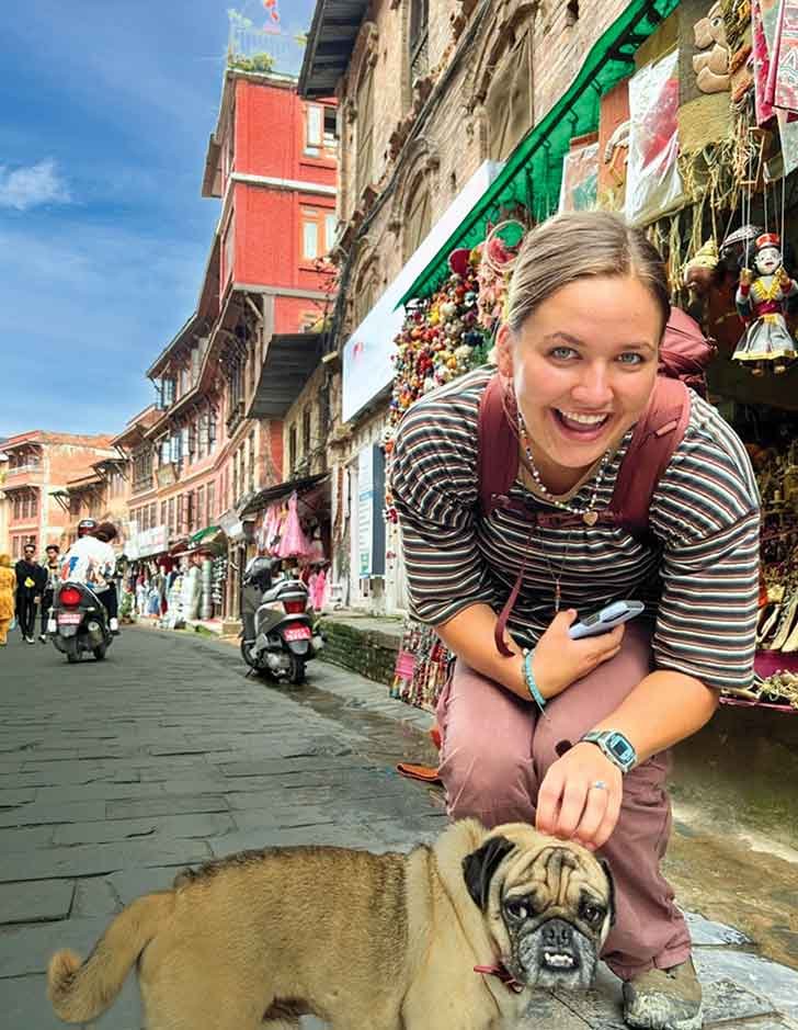 a student poses with a dog at an outdoor market