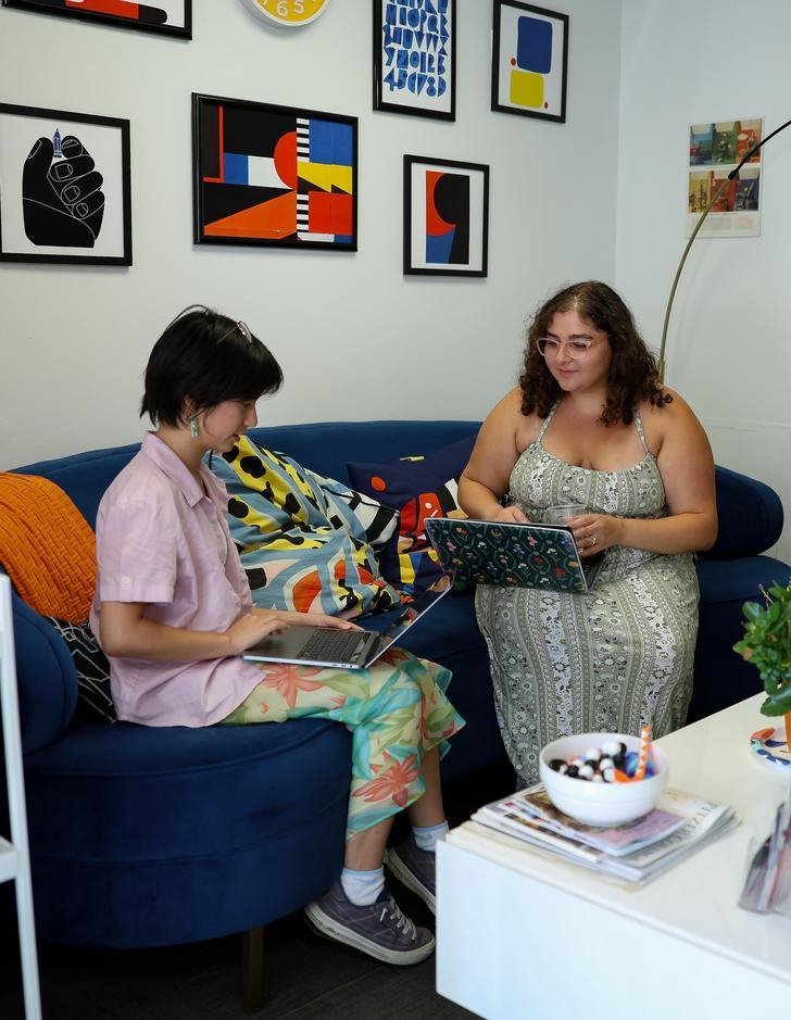 two students sitting on a blue sofa in the writing center