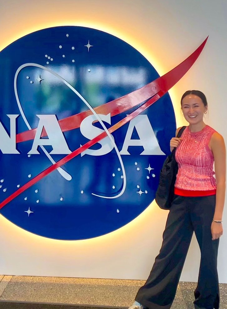 a student stands in front of a NASA sign