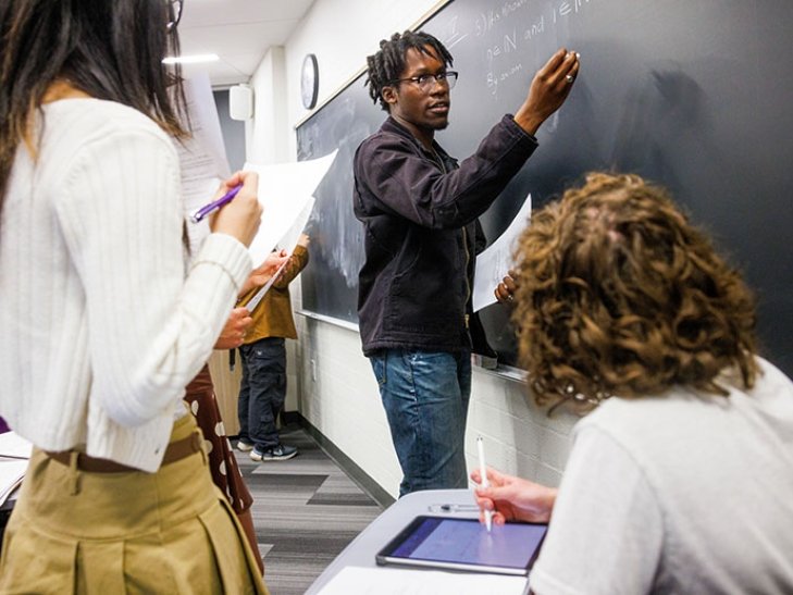 a student solves a problem on the blackboard