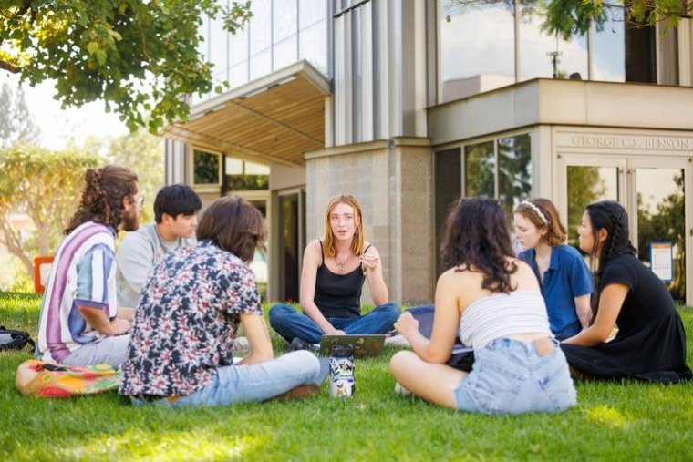 Students sit in a circle outside Benson Auditorium