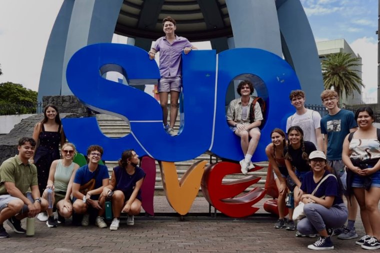 Students in front of blue sigh